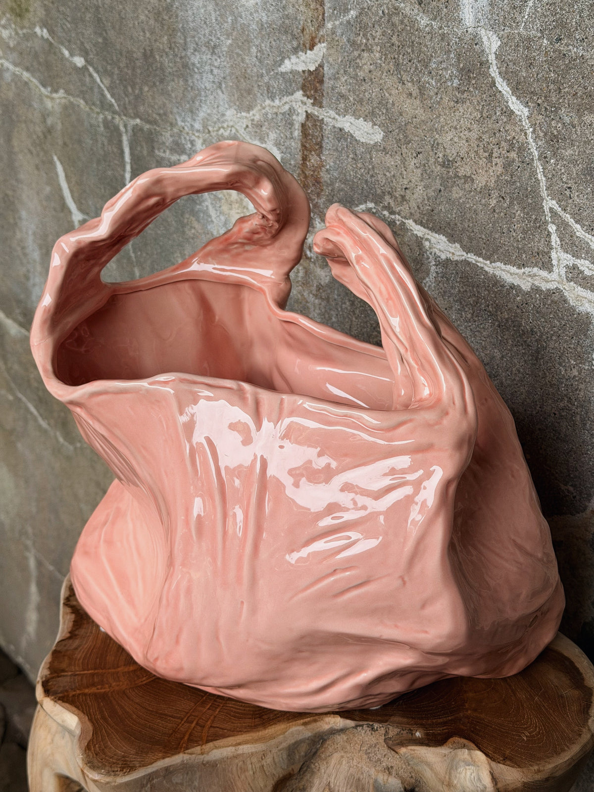 Detail van de roze vaas met opstaande oren en glanzende plooien in het keramiek