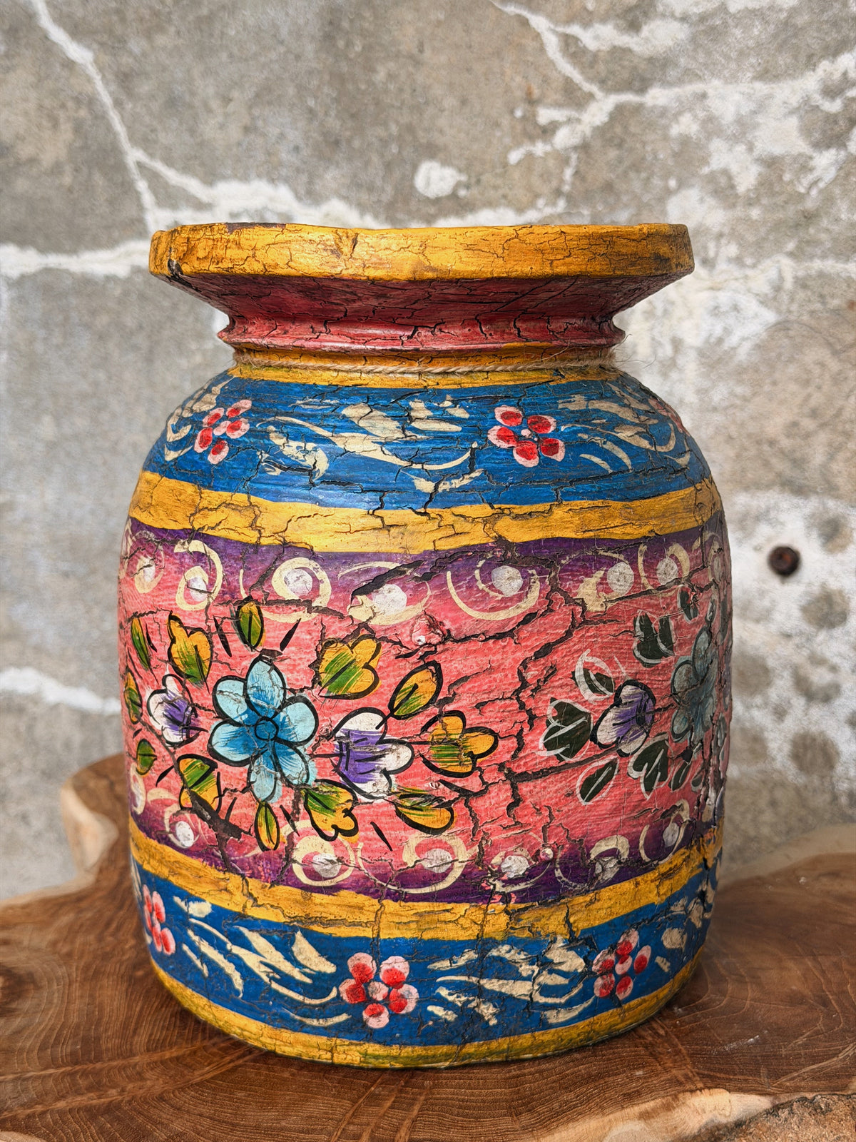 Roze buik met turquoise en gele bloemen tussen blauwe banden met witte ranken