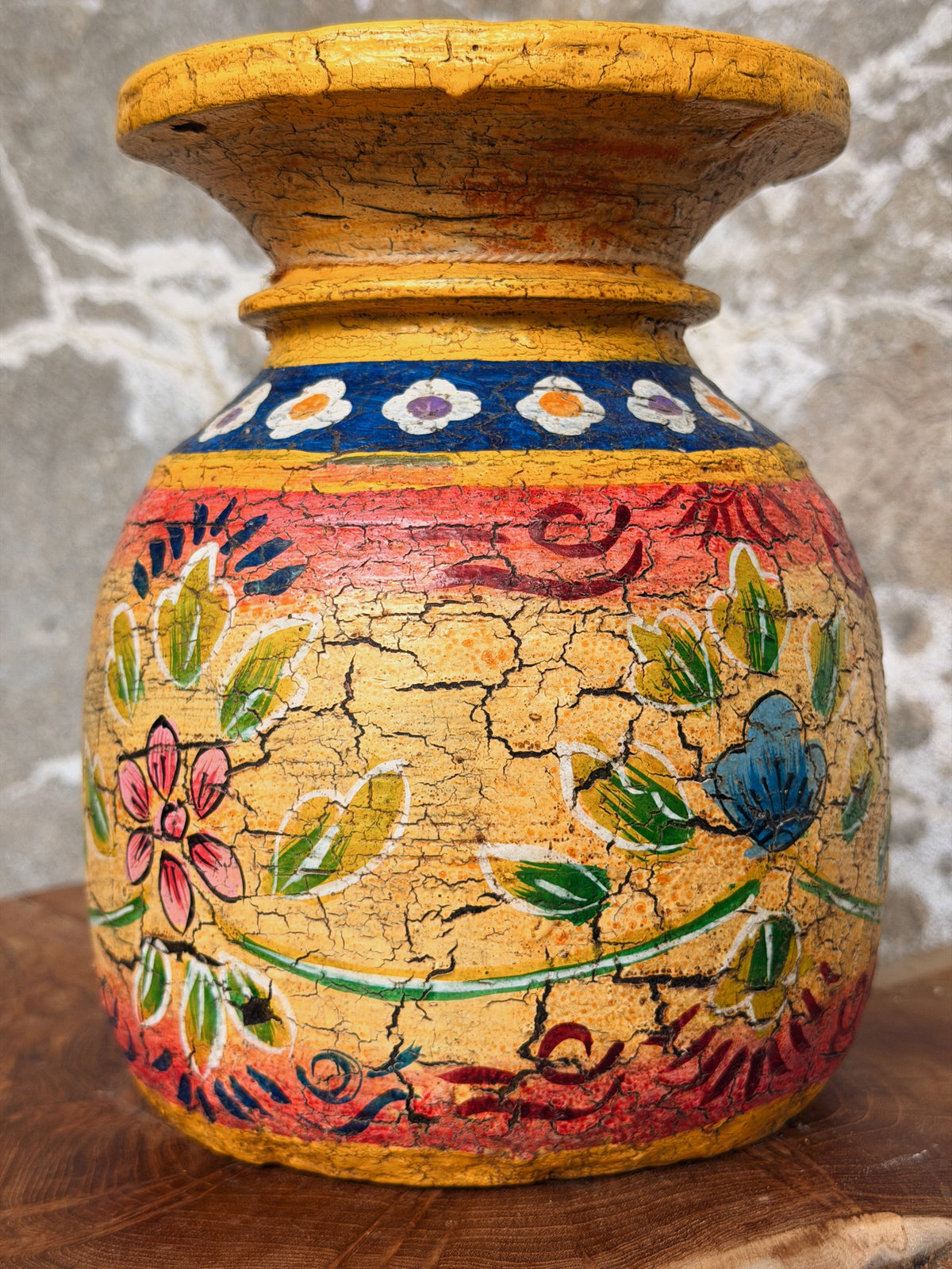 Close-up van het handgeschilderde bloemdecor in geel, rood, groen en blauw met craquelé