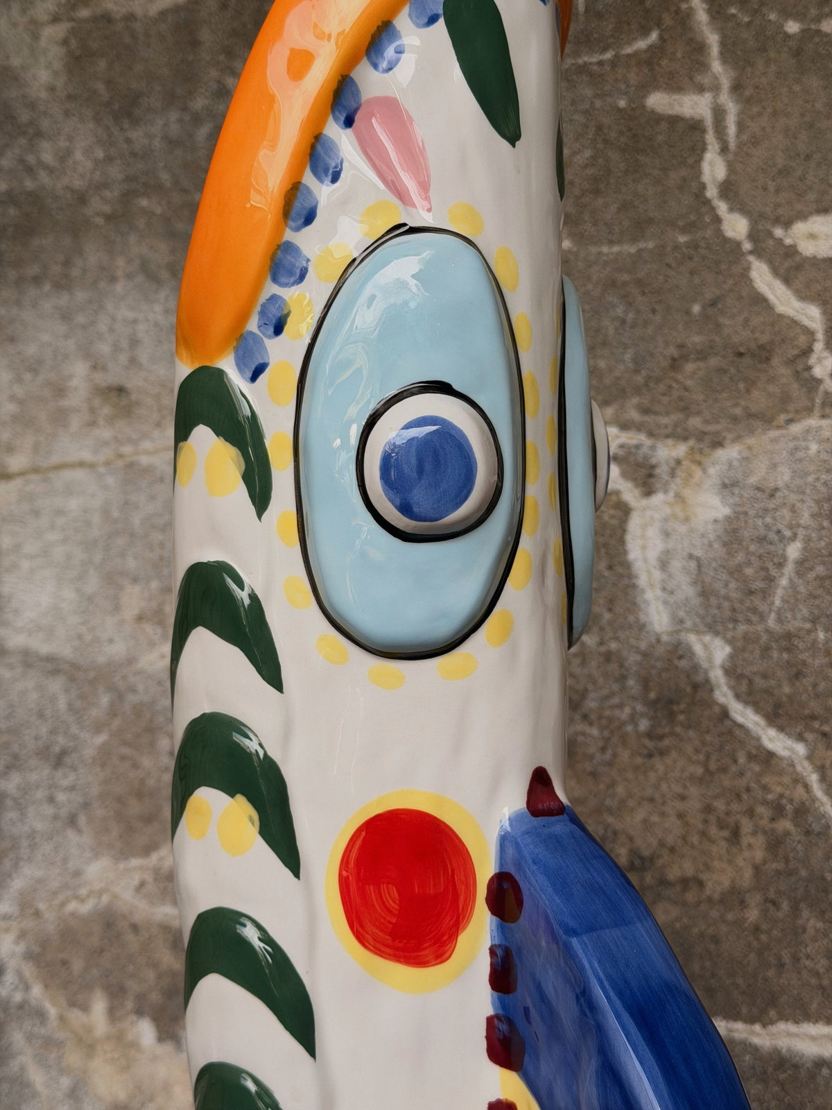 Close-up van het lichtblauwe oog met gele stippen en groene strepen op wit keramiek